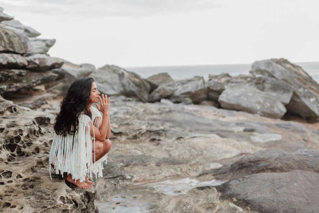 Mujer meditando entre las rocas.